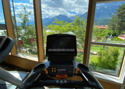 Trainingsgerät vor Fensterfront mit Ausblick auf die Berge